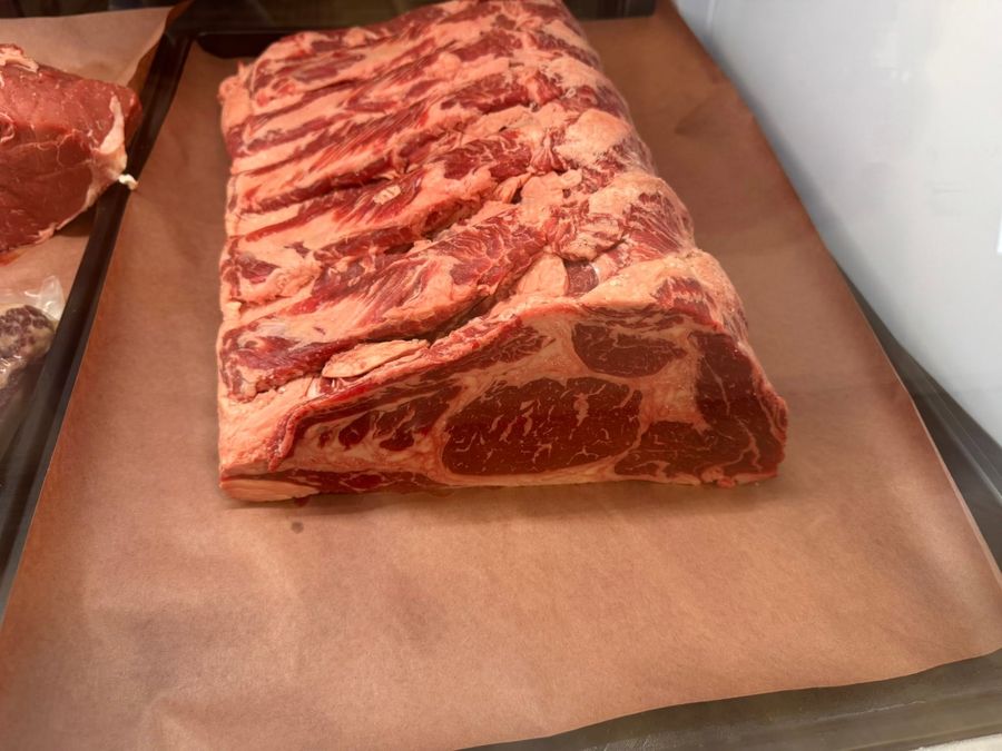 Close-up of a well-marbled bone-in ribeye on butcher paper